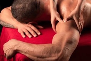 Man performing a sports massage on another man's back